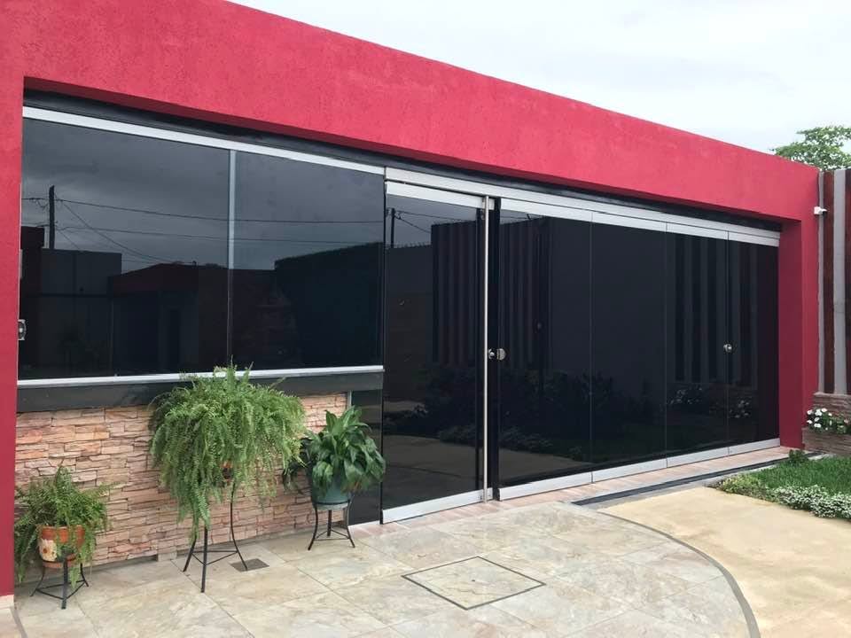 Frente vidriado de una casa con blindex polarizado en puerta y ventanales